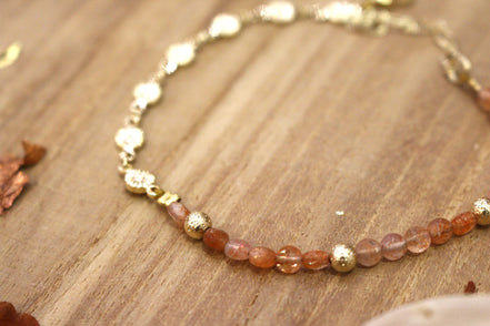 bracelet orné de petites fleurs en laiton doré et pierre de soleil