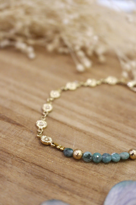 bracelet orné de petites fleurs dorées et de perles émeraude brut
