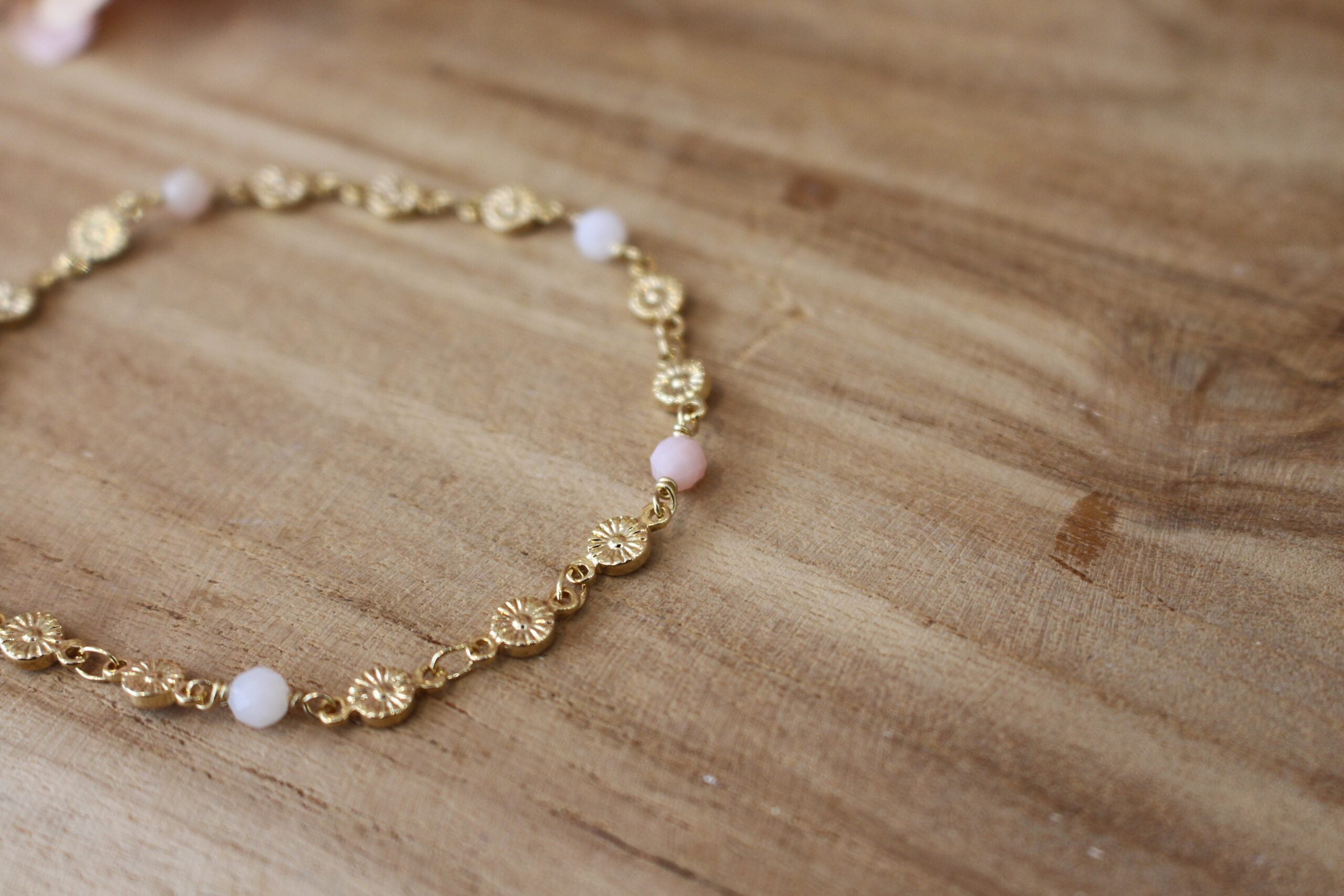bracelet pour femme collection printemps de Kassiopeia,, composé d'une chaîne de fleurs dorées et de perles d'opale rose
