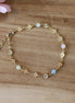 bracelet doré pour femme, composé d'une chaine en fleurs dorées et de perles d'aigue marine