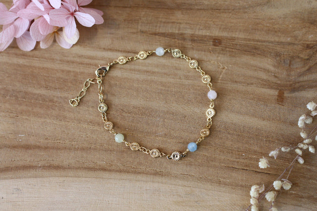 bracelet doré pour femme, composé d'une chaine en fleurs dorées et de perles d'aigue marine