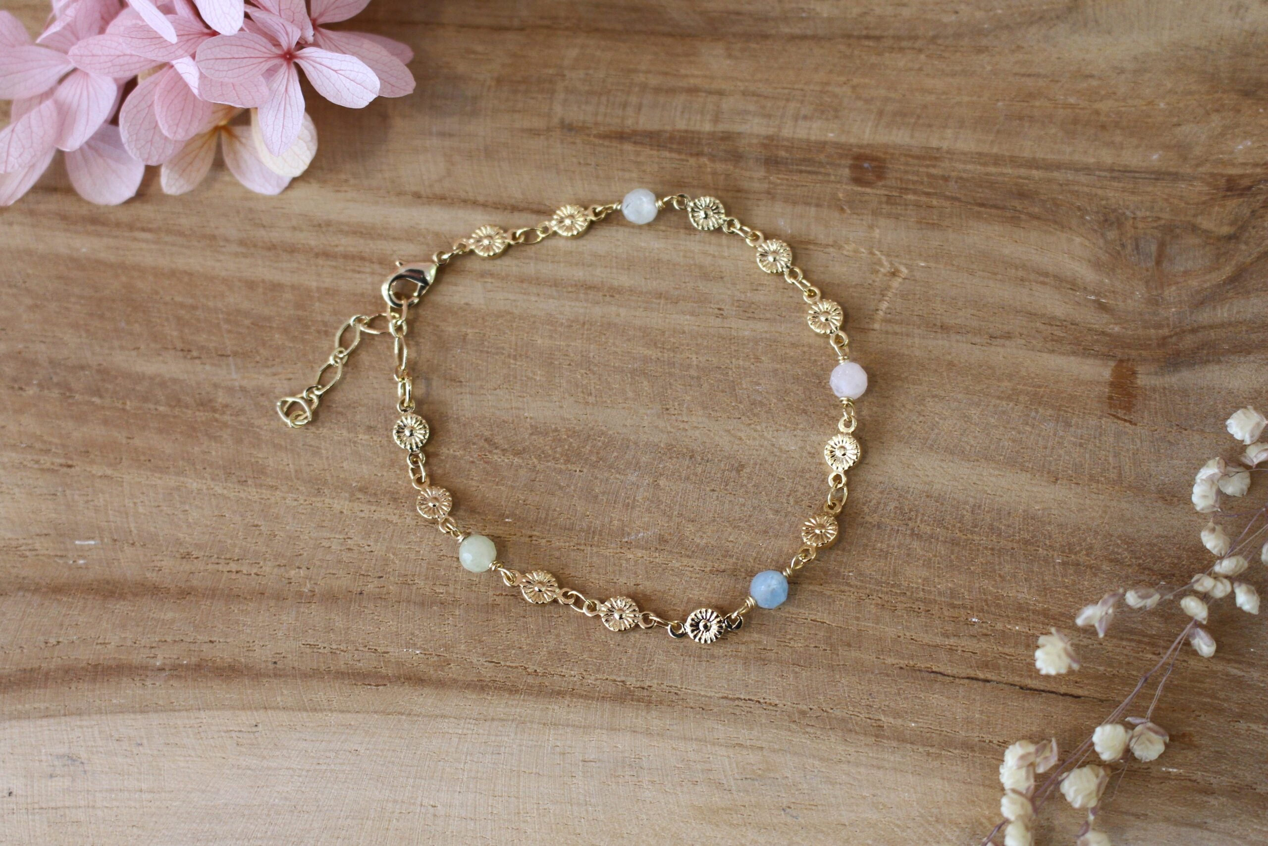 bracelet doré pour femme, composé d'une chaine en fleurs dorées et de perles d'aigue marine