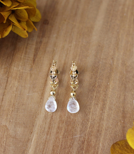 boucles d'oreilles dorées en forme de créoles avec un pendentif en pierre de lune