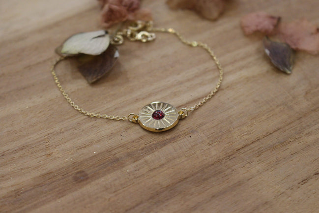 bracelet gourmette et médaille soleil plaqué or orné d'un grenat