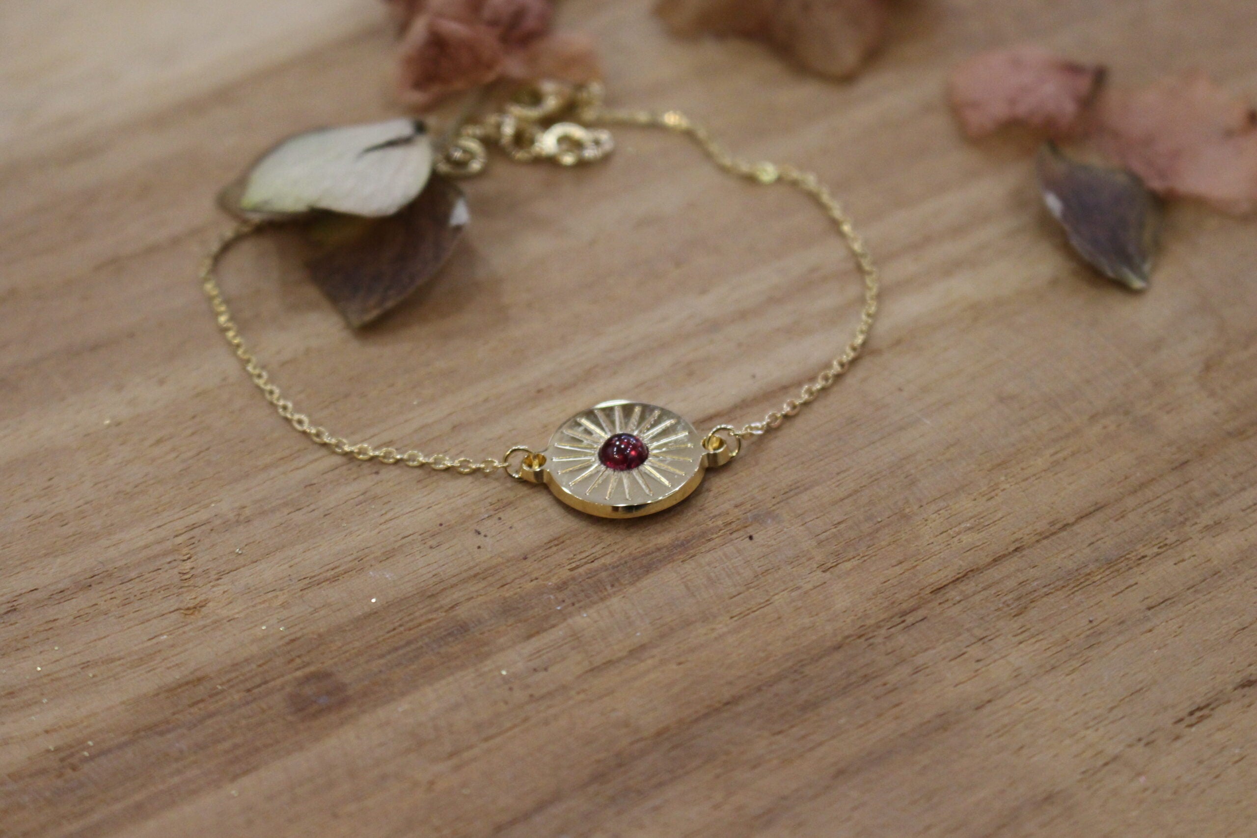bracelet gourmette et médaille soleil plaqué or orné d'un grenat